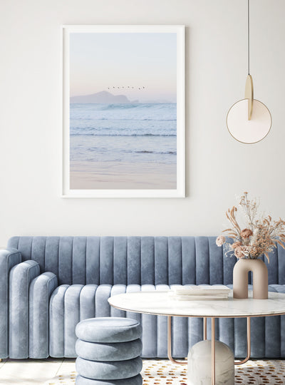 Framed Number One Beach at Sunset artwork above a blue sofa in a living room