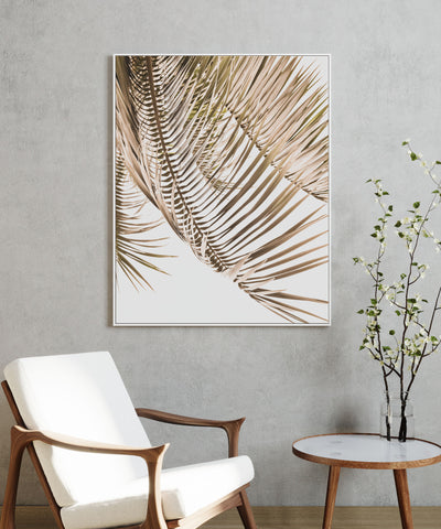 Framed Kentia Palm View print on canvas on a wall above a chair and table
