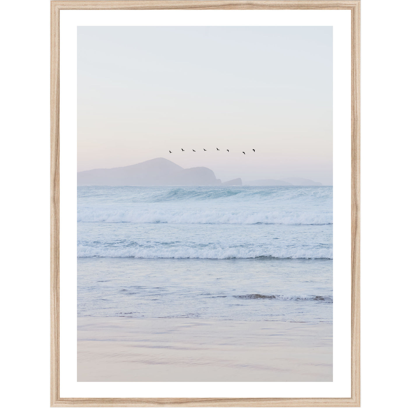 Framed artwork of a beach at sunset with birds over water