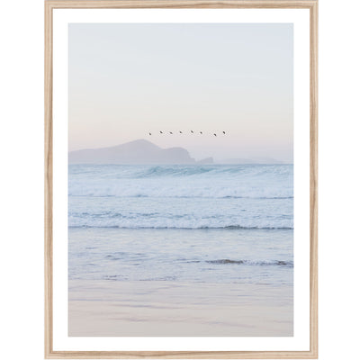 Framed artwork of a beach at sunset with birds over water