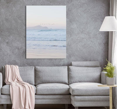 Gray sofa with a pink blanket in a mder living room with a stretched canvas print of Number One Beach at Sunset artwork.